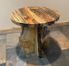 a round wooden table sitting on top of a tiled floor