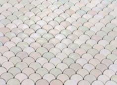 an image of a white tile pattern that looks like fish scales