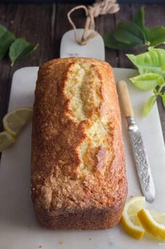 a loaf of lemon bread sitting on top of a cutting board next to a knife