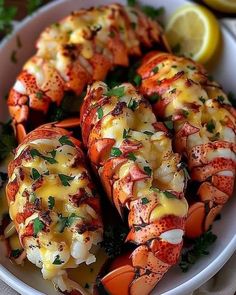 cooked lobsters on a plate with lemon wedges and parsley garnish