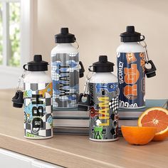 an assortment of water bottles sitting on top of a counter next to an orange slice