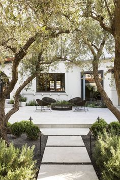 an outdoor patio with chairs and trees