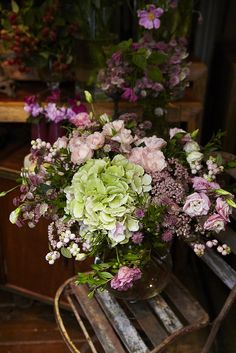 a vase filled with lots of flowers sitting on top of a wooden table next to a piano