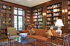 a living room filled with lots of furniture and bookshelves covered in bookcases