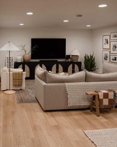 a living room filled with furniture and a flat screen tv mounted to the side of a wall