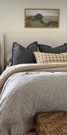 a bed with black and white striped sheets, pillows and blankets on top of it