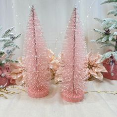 two pink vases with christmas trees in the background