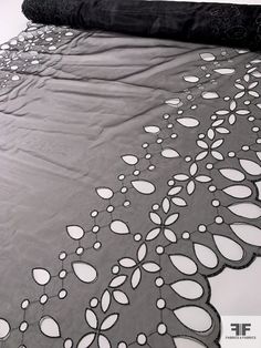 a black and white photo of a bed with an intricately designed coverlet on it