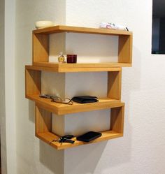 three wooden shelves on the wall with shoes and other items sitting on top of them