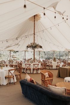 the inside of a tent with tables and chairs set up for an outdoor function or party