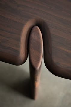 the back end of a wooden chair with curved wood graining on it's sides