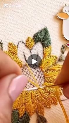 someone is working on an embroidery project with scissors