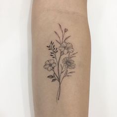 a black and white flower tattoo on the right thigh, with small flowers growing out of it