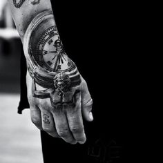 black and white photo of a man's arm with a compass tattoo on it