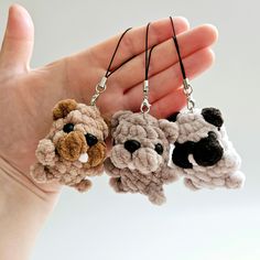 three small crocheted animals are being held in the palm