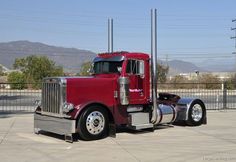 a red semi truck parked in a parking lot