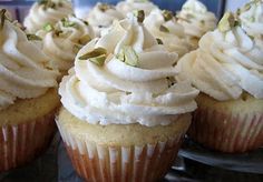 several cupcakes with white frosting and pistachio sprinkles