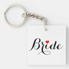 a square keychain with the word bride written on it and a red heart