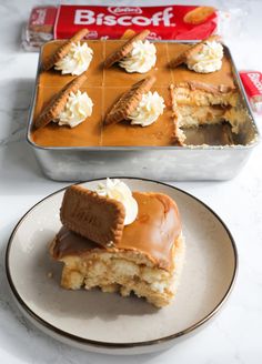 a piece of cake sitting on top of a white plate next to a box of biscuits