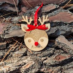 a wooden ornament with a red bow on it's head and antlers