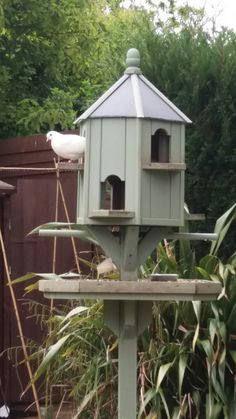 a bird house sitting on top of a wooden pole