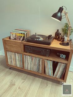 an old record player is sitting on top of a wooden cabinet with records in it