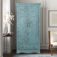 an ornate blue armoire in a living room