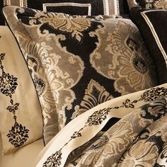 a bed covered in black and white pillows