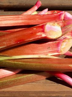 some red and green vegetables are on a wooden table, ready to be cut into wedges