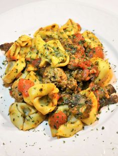 a white plate topped with pasta covered in sauce