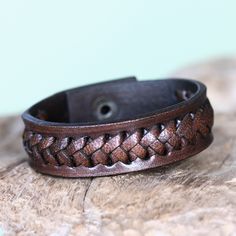 This bold bracelet by Tomomi showcases braided textures. Featuring interlacing created by hand, the wristband is handcrafted of brown leather. Adjustable Brown Leather Bracelet With Wrist Strap, Handmade Leather Braided Bracelet, Adjustable Brown Cuff Bracelet With Bracelet Strap, Adjustable Brown Cuff Bracelet With Strap, Brown Leather Strap Bracelet, Adjustable Brown Wristband With Bracelet Strap, Adjustable Brown Bracelet With Wrist Strap, Handmade Distressed Brown Adjustable Bracelet, Adjustable Leather Braided Bohemian Bracelets