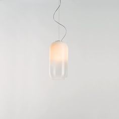 a light that is hanging from a wire on the ceiling with a white wall in the background