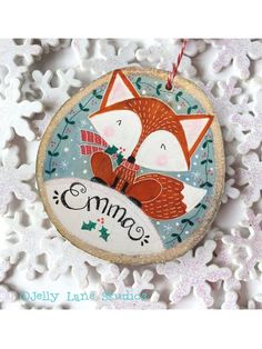 a christmas ornament with a red fox and snowflakes on the background