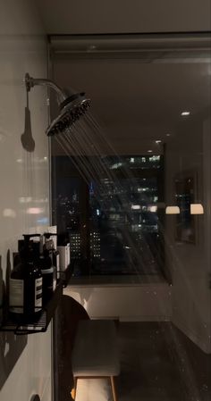 a shower head in the middle of a bathroom with city lights on it's walls