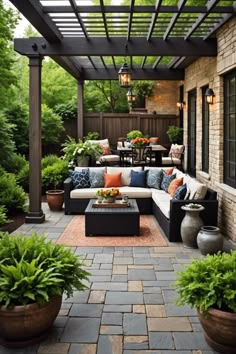 an outdoor living area with couches, tables and potted plants