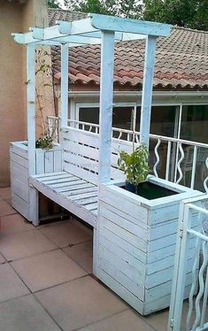 a white wooden bench sitting on top of a patio