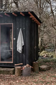 the outside of a black cabin with a white towel hanging on it's door