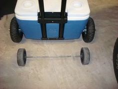 a blue and white cooler sitting on top of a floor next to a black wheel