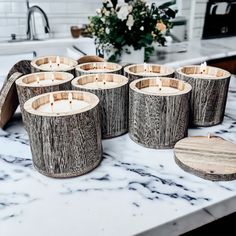 candles are lined up on a marble counter top