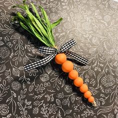 an orange carrot tied to a black and white ribbon on top of a table cloth