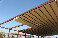 an outdoor covered area with tables and umbrellas in the background on a sunny day