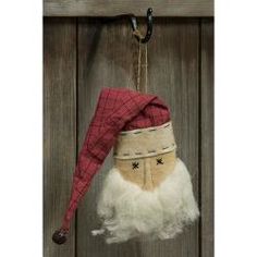 an old fashioned christmas stocking hanging from a hook on a wooden door with a red and white santa claus hat