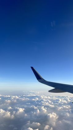 an airplane wing flying above the clouds