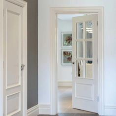 an open door leading to another room with white walls and wood flooring on the other side