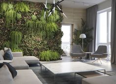 a living room with couches, chairs and a wall covered in green moss plants