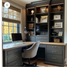 a home office with built - in bookcases, desk and computer on it