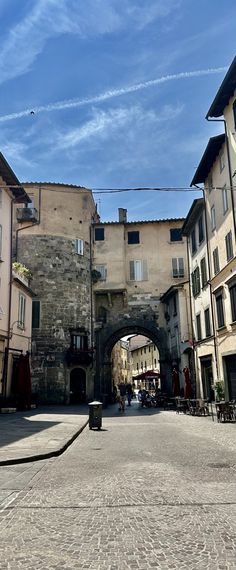 an arch in the middle of a cobblestone street