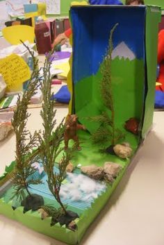 an open box with trees and rocks in it on a table next to other children's toys