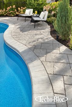 an empty swimming pool with lounge chairs around it