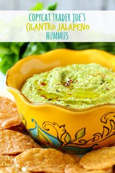 a yellow bowl filled with guacamole surrounded by tortilla chips